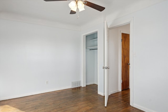 unfurnished bedroom with a closet, dark hardwood / wood-style floors, and ceiling fan