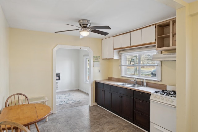 kitchen featuring sink, ceiling fan, white cabinetry, dark brown cabinets, and white range with gas cooktop