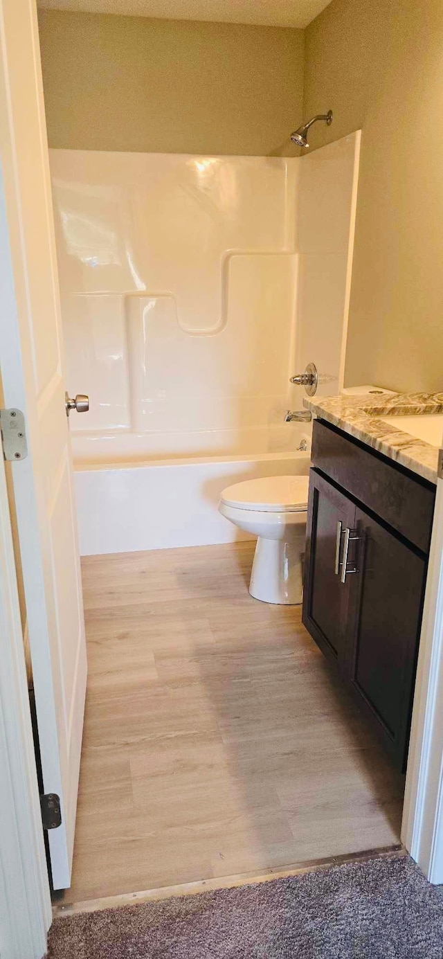 full bathroom featuring vanity, tub / shower combination, hardwood / wood-style floors, and toilet