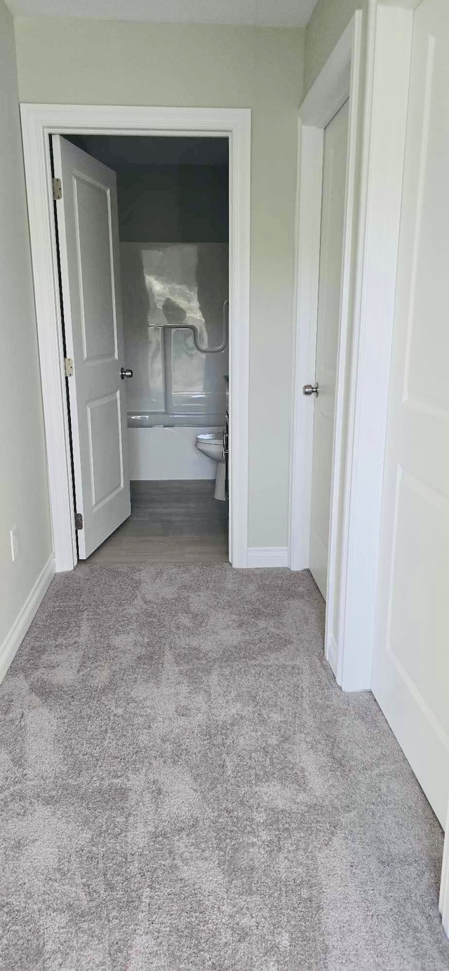 unfurnished bedroom featuring light colored carpet and ensuite bathroom