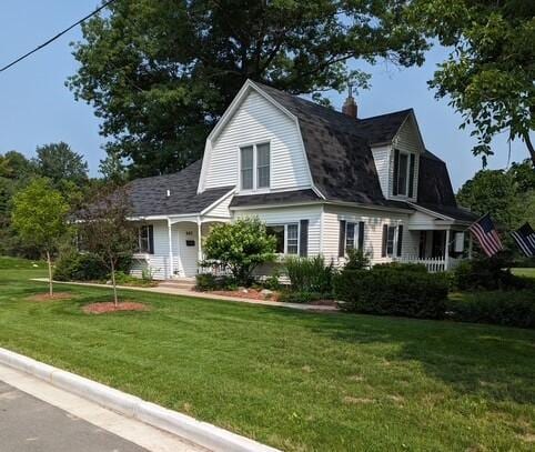 602 Rust Ave, Big Rapids, MI 49307 - view of front of home featuring a gambrel roof, a front yard, and a chimney