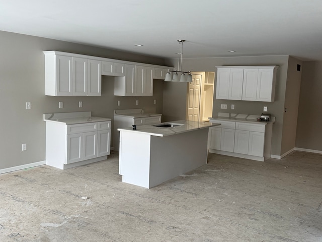 kitchen with a kitchen island, sink, white cabinets, and decorative light fixtures