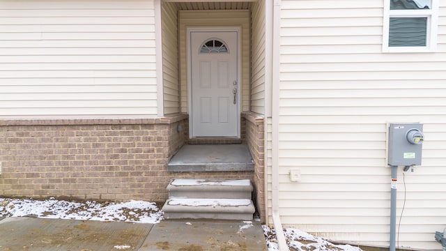 view of exterior entry with brick siding