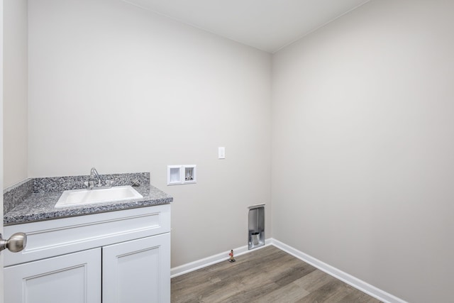 washroom with gas dryer hookup, hookup for a washing machine, wood finished floors, a sink, and baseboards