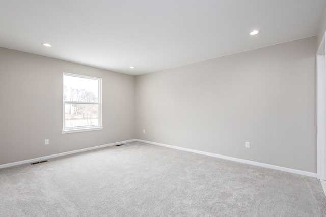 unfurnished room featuring baseboards, visible vents, light colored carpet, and recessed lighting