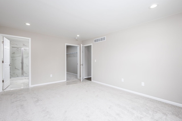 unfurnished bedroom featuring visible vents, light carpet, and baseboards