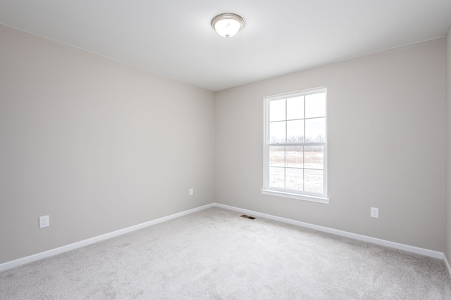 carpeted spare room featuring visible vents and baseboards