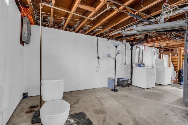 basement with electric panel and washer and clothes dryer