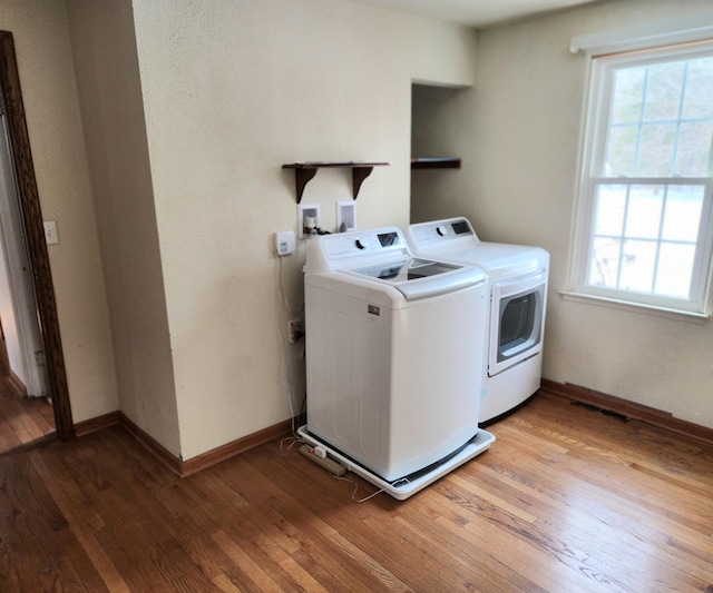 laundry room with washer and clothes dryer, laundry area, light wood-style flooring, and baseboards