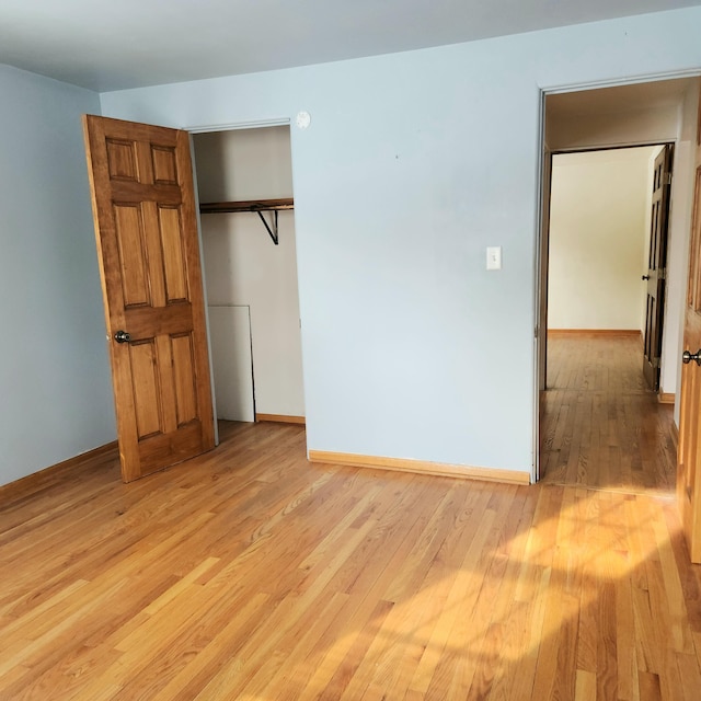 unfurnished bedroom with light wood-style flooring and baseboards