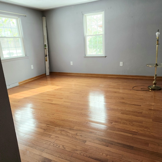 empty room with baseboards and hardwood / wood-style floors