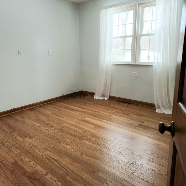 unfurnished room featuring visible vents, baseboards, and light wood-style flooring