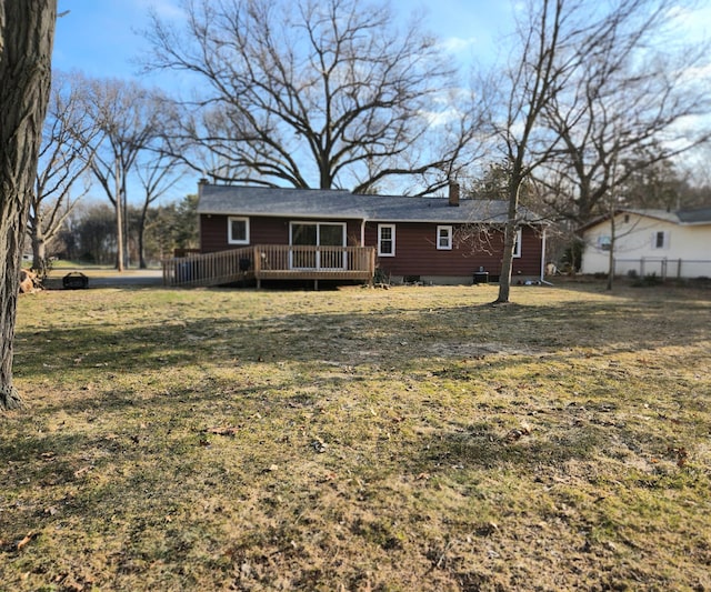 back of house featuring a yard, fence, a chimney, and a wooden deck