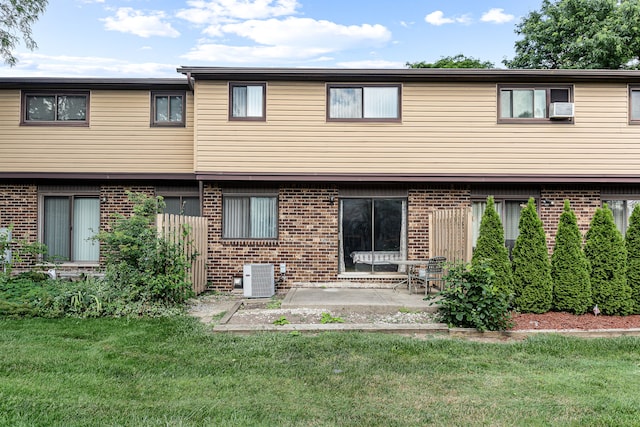 rear view of property with a yard, central AC unit, and a patio