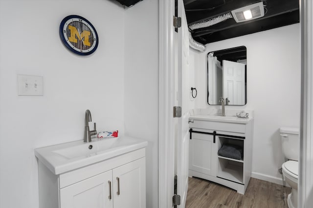 bathroom with hardwood / wood-style flooring, vanity, and toilet