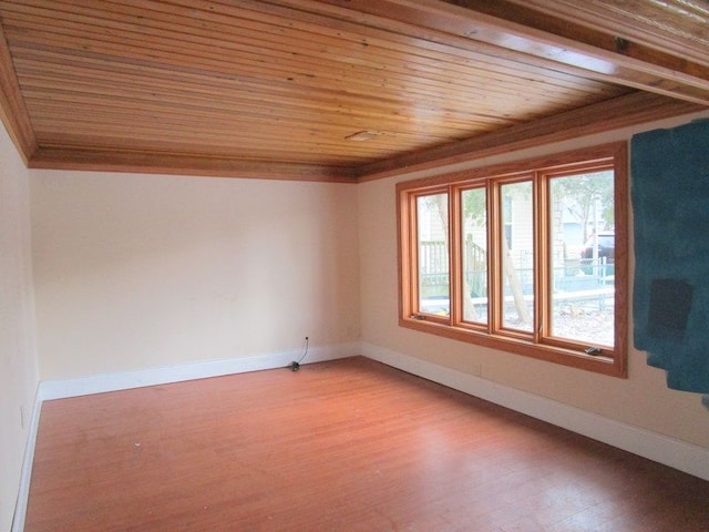 spare room featuring crown molding, hardwood / wood-style floors, and wood ceiling