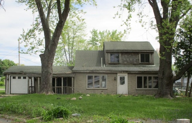 124 Roselawn St, Algonac, MI 48001 - view of front of property featuring a garage, a front lawn, brick siding, and a sunroom