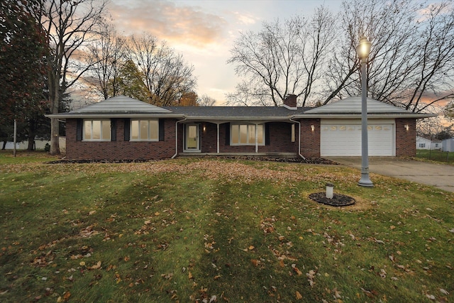 ranch-style home featuring a garage and a yard