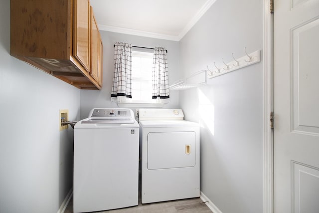 laundry room with cabinets, crown molding, separate washer and dryer, and light hardwood / wood-style flooring