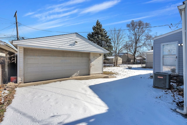 snow covered garage featuring central AC unit