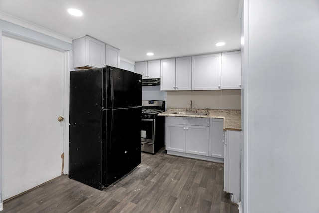 kitchen with sink, black refrigerator, stainless steel range with gas stovetop, white cabinets, and dark hardwood / wood-style flooring