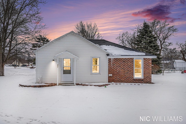 view of snow covered back of property