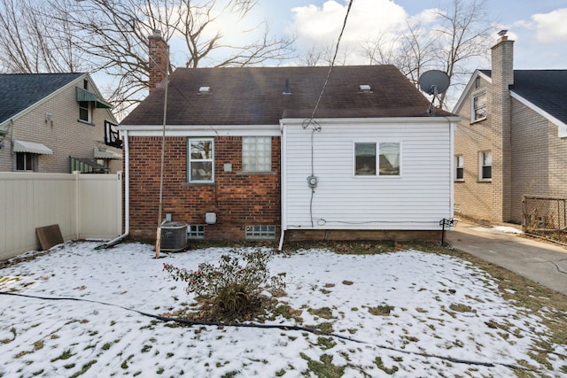 snow covered property with central air condition unit