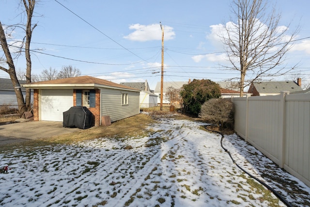 yard layered in snow with a garage and an outdoor structure