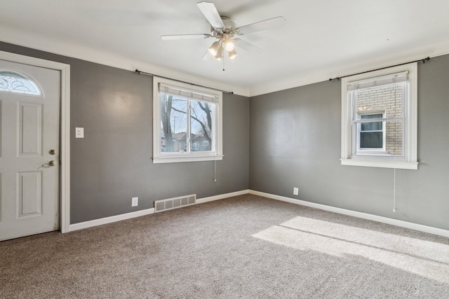 carpeted spare room featuring ceiling fan