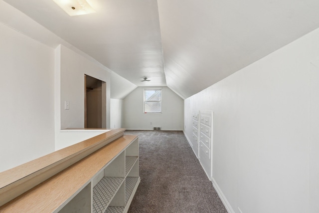 additional living space with vaulted ceiling and dark carpet