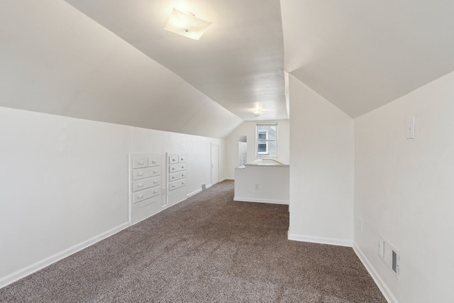 additional living space with lofted ceiling and dark carpet