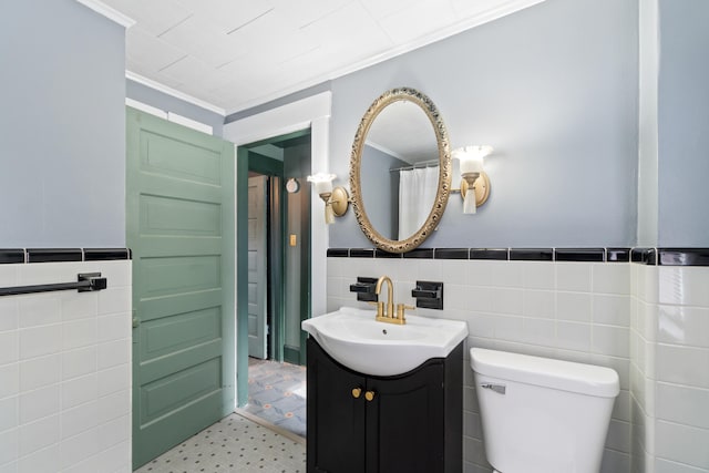 626 Orange St, Jackson, MI 49202 - bathroom featuring tile walls, vanity, crown molding, toilet, and wainscoting