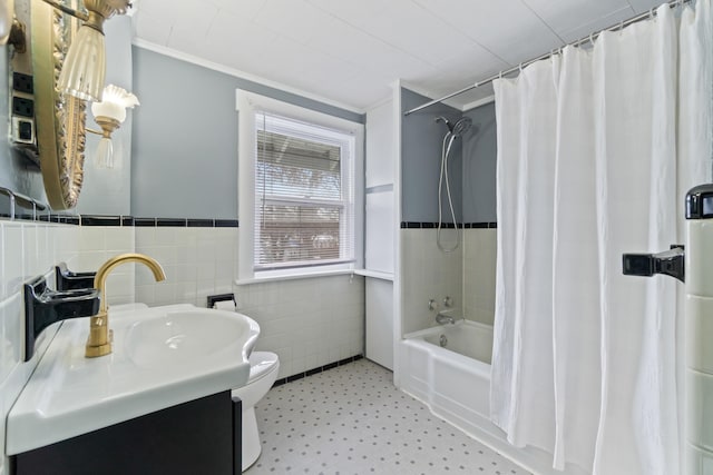 626 Orange St, Jackson, MI 49202 - bathroom featuring tile walls, tile patterned floors, toilet, a wainscoted wall, and shower / bath combo
