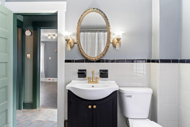 626 Orange St, Jackson, MI 49202 - bathroom featuring vanity, tile walls, and toilet