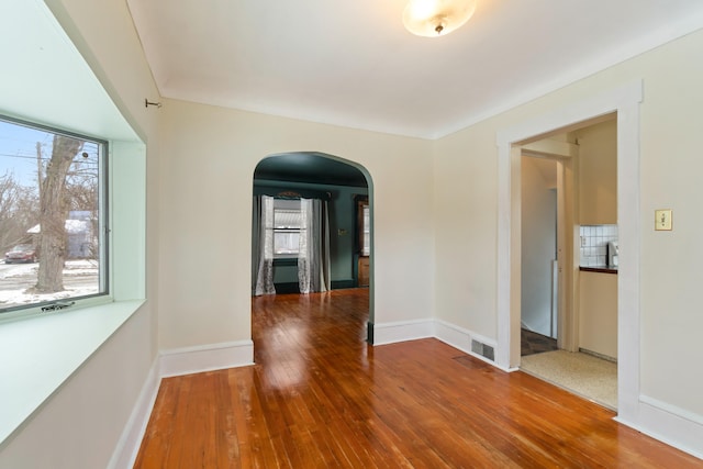 626 Orange St, Jackson, MI 49202 - unfurnished room featuring arched walkways, wood-type flooring, and baseboards