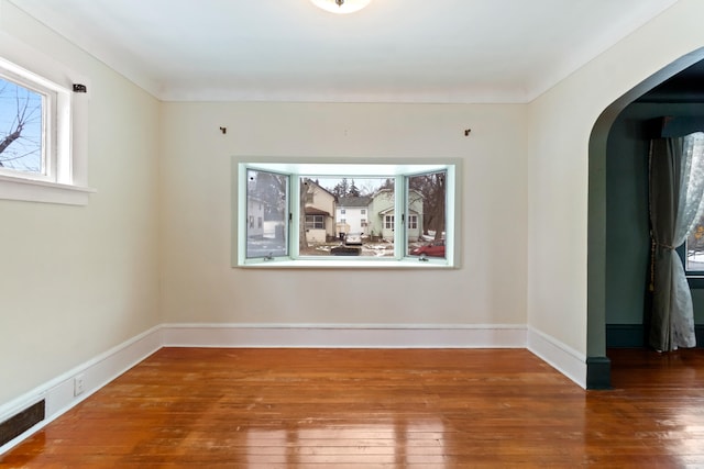 626 Orange St, Jackson, MI 49202 - spare room featuring arched walkways, hardwood / wood-style floors, and baseboards