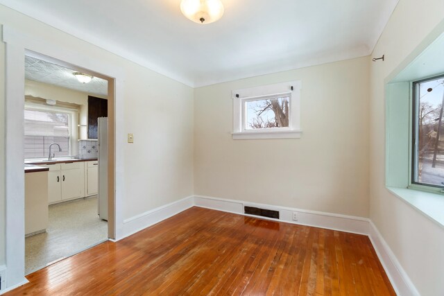 626 Orange St, Jackson, MI 49202 - unfurnished room with wood-type flooring, a sink, and baseboards