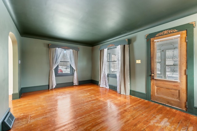 626 Orange St, Jackson, MI 49202 - empty room featuring arched walkways, light wood finished floors, and baseboards