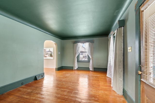 626 Orange St, Jackson, MI 49202 - unfurnished bedroom featuring wood finished floors, arched walkways, and baseboards