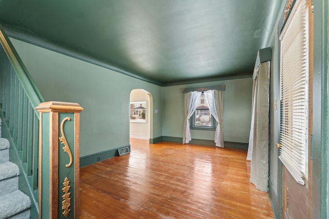 626 Orange St, Jackson, MI 49202 - empty room with arched walkways, wood finished floors, and stairway