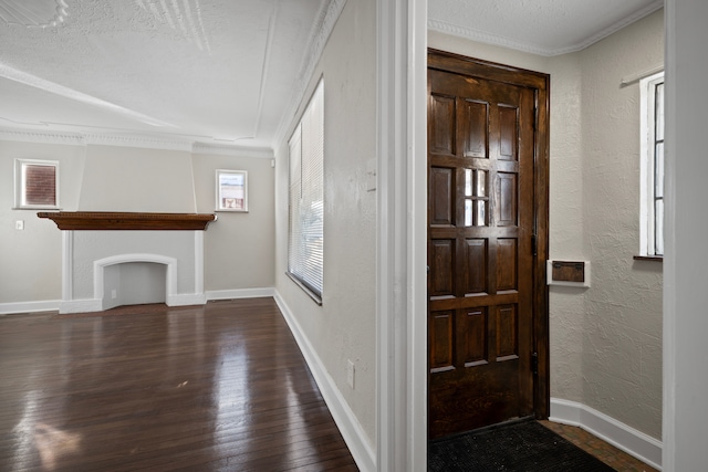 entrance foyer with a fireplace, ornamental molding, dark hardwood / wood-style floors, and a textured ceiling