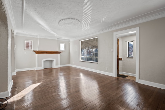 unfurnished living room featuring dark wood-type flooring, crown molding, and a textured ceiling