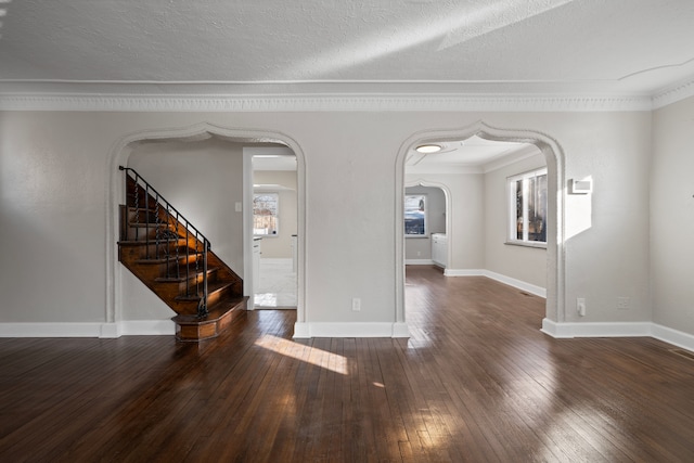 empty room with crown molding, dark hardwood / wood-style floors, and a textured ceiling