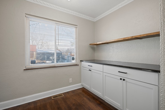 interior space with dark wood-type flooring and ornamental molding