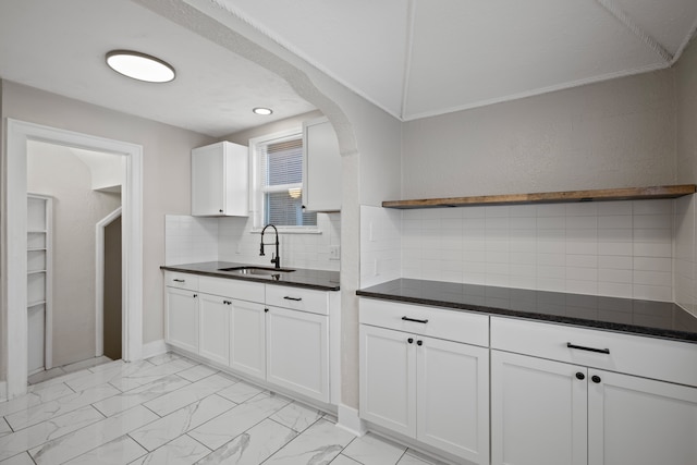 kitchen featuring white cabinetry, sink, and tasteful backsplash