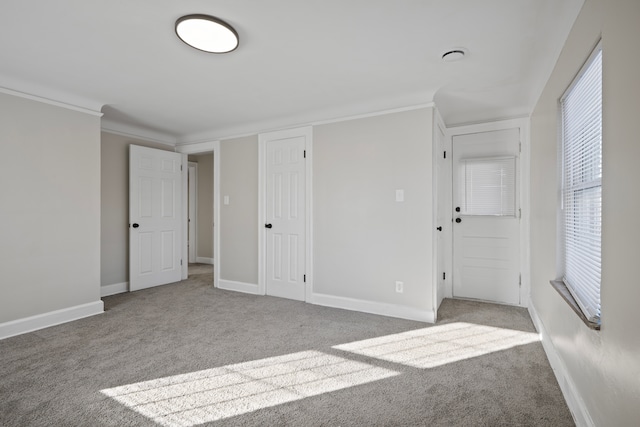 carpeted spare room featuring crown molding