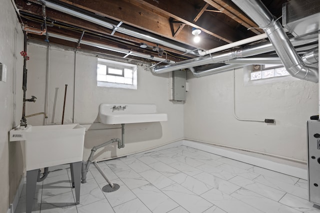 basement featuring electric panel and sink