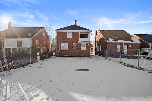 view of snow covered back of property