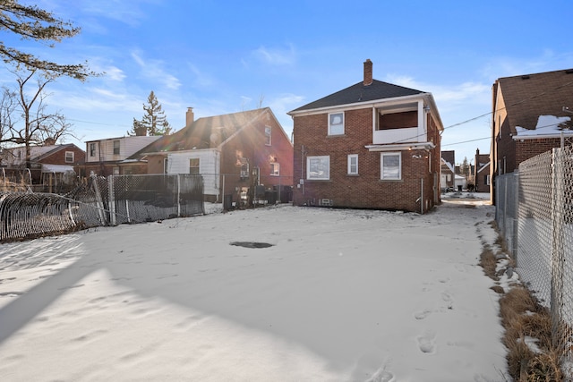 view of snow covered back of property