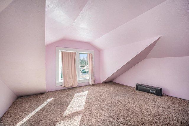 additional living space featuring lofted ceiling and carpet flooring